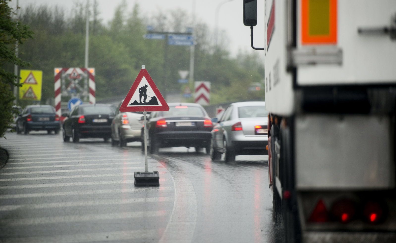 This picture taken on a belgian motorway shows traffic jam caused by road works as workers pose a new asphalt surface or reparations on a damaged road